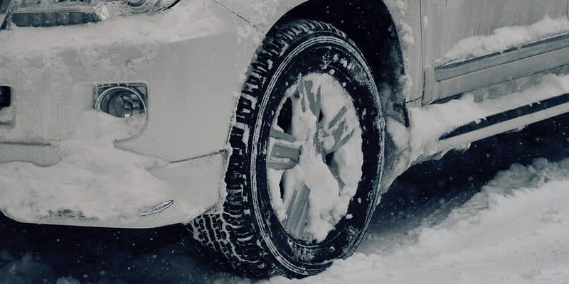 White car partially covered in snow