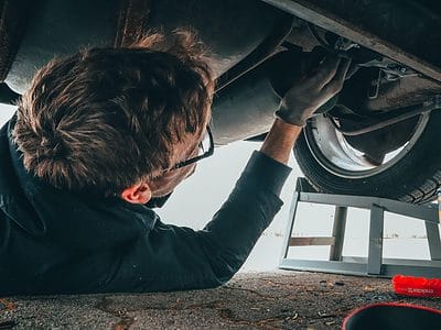 Man under a car changing the oil