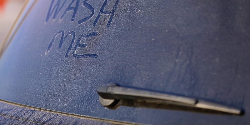 Dirty car with wash me sign