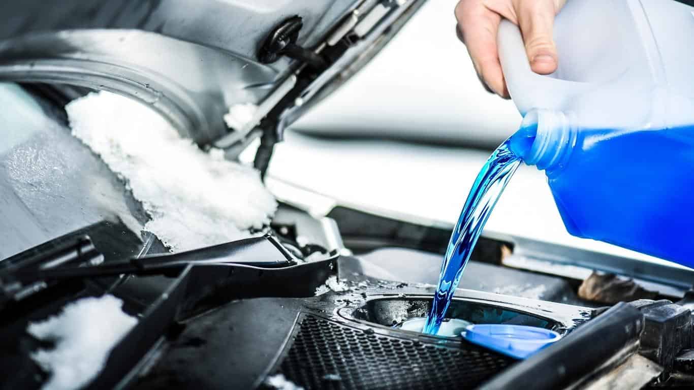 Pouring blue windshield washer fluid into the compartment