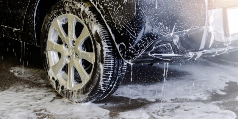 Black car and parts of ground covered in soap